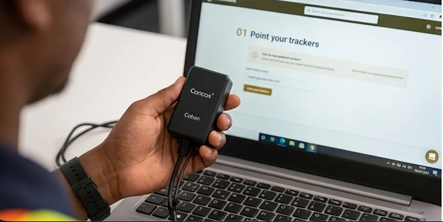 Technician holding a Concox GPS tracker next to a laptop showing GeoSavanna device setup.